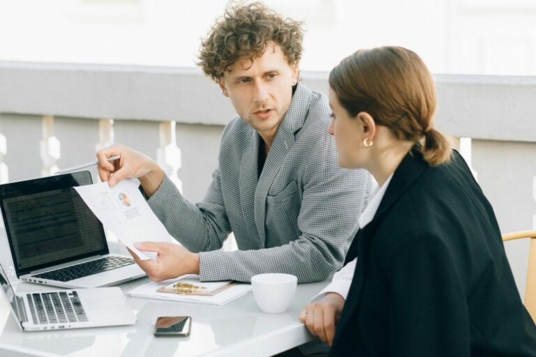Deux adultes échangent autour d’un dossier lors d’un rendez-vous de travail